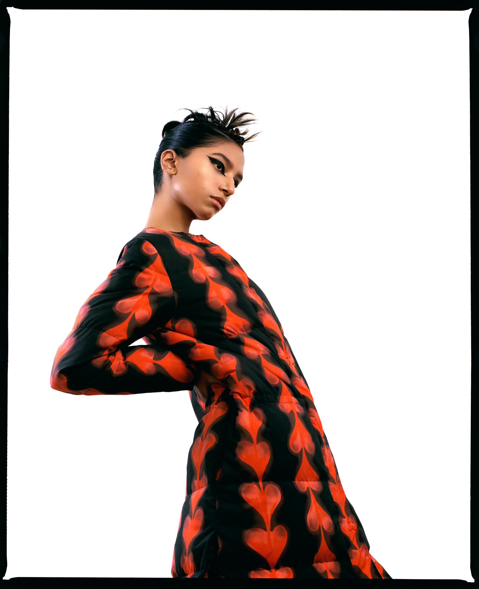 Tara Raani, queer model and actress, know for her role as Zaara Ali on the television sitcom grown-ish. Wearing a red and black jacket, dark cat eye makeup by Malisa Khamphong, spiky hair by hairstylist Jason Linkow, studio setup, white backdrop, photographed by New York fashion photographer Maria Bruun. Photographed using the Mamiya RZ67 camera and Kodak Portra film. Editorial for Flanelle Magazine.
